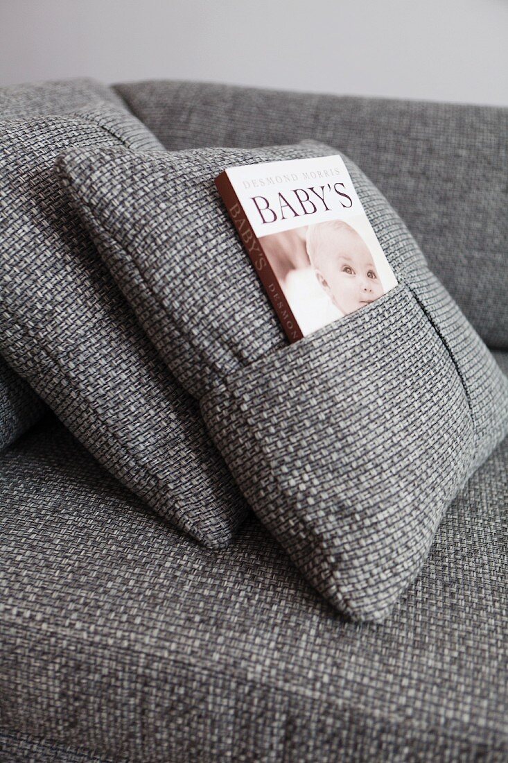 Grey marl cushion cover with book inserted in integrated pocket