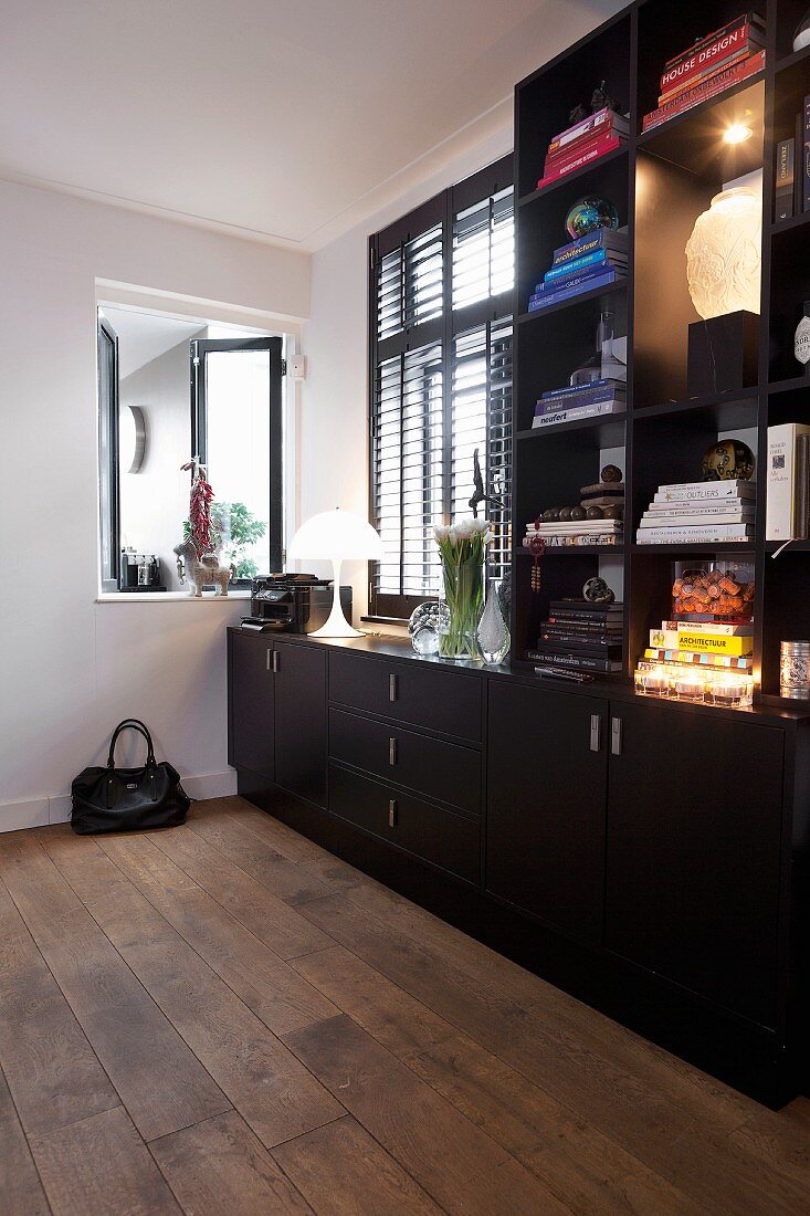 Black-painted, fitted wooden cabinets and open interior window