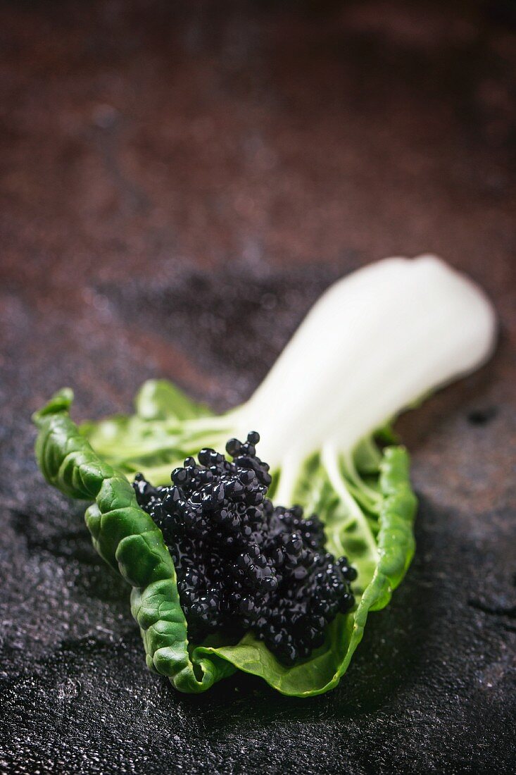 Black caviar on a chard leaf