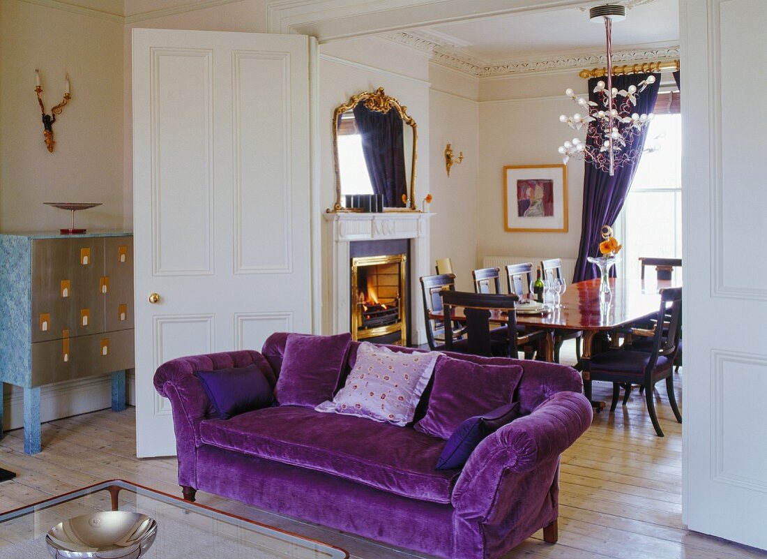 Georgian Chesterfield sofa with purple upholstery, Italian, designer cabinet with silver front and folding, sliding doors leading to elegant dining room