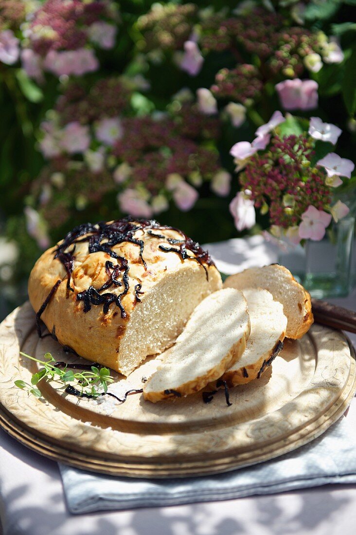 Sliced onion bread on a wooden plate for a picnic