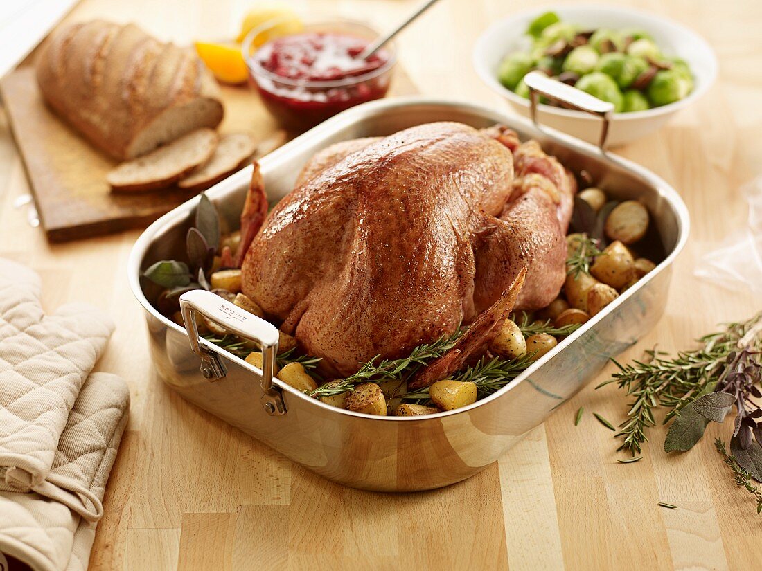 Roast turkey with potatoes and rosemary in a roasting tin
