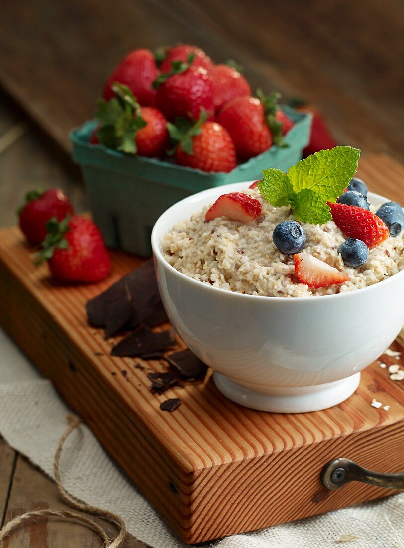 Porridge with blueberries and strawberries on a chopping board