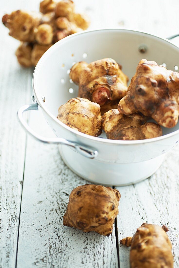Jerusalem artichokes in a bowl of a wooden table