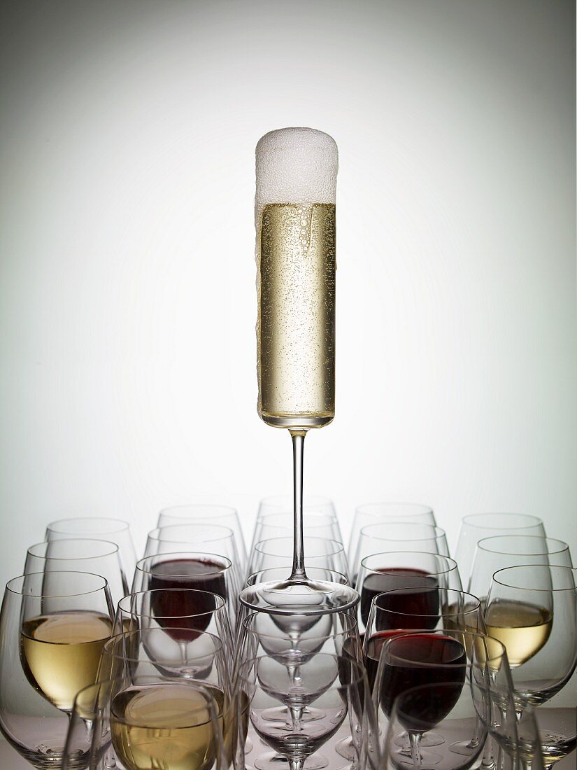 A glass of champagne balanced on wine glasses