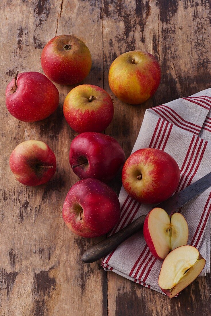 Frische rote Äpfel mit Geschirrtuch und Messer