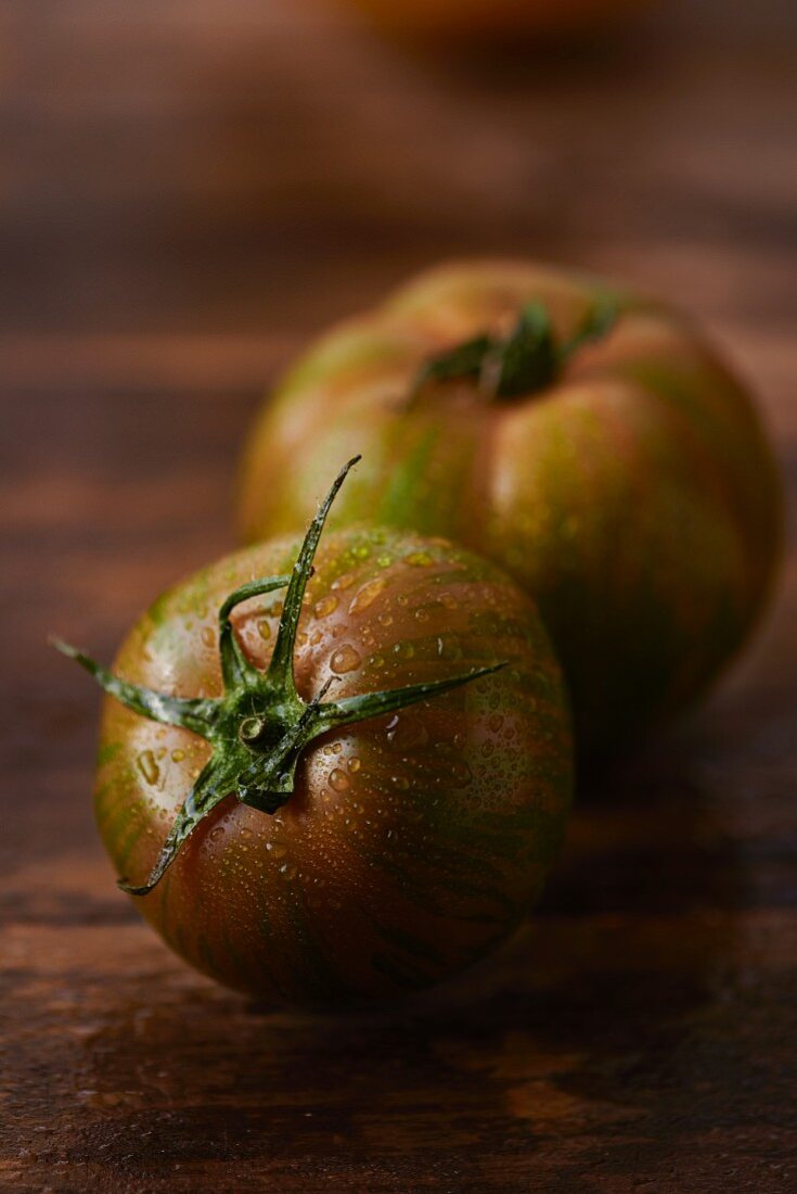 Two tomatoes with drops of water