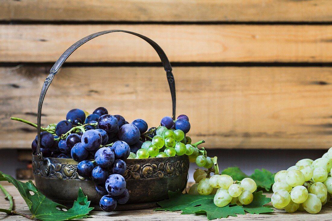 Red and green grapes in a metal basket