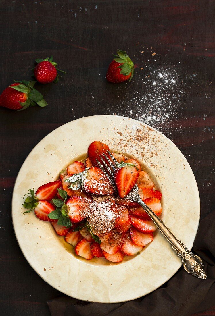 Strawberries with grated chocolate and icing sugar