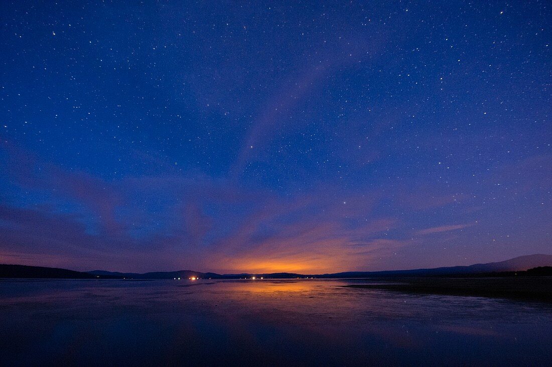 A calm lake under a beautiful starry sky