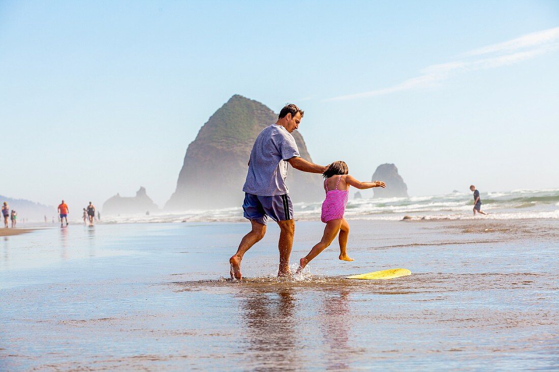 Father and daughter with a surf beach in the shallows