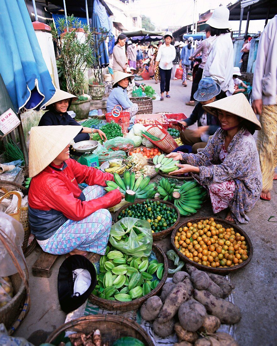 Frauen mit konischen Hüten verkaufen Obst und Gemüse im belebten Zentralmarkt, Hoi An, Zentral-Vietnam, Vietnam, Indochina, Südostasien, Asien