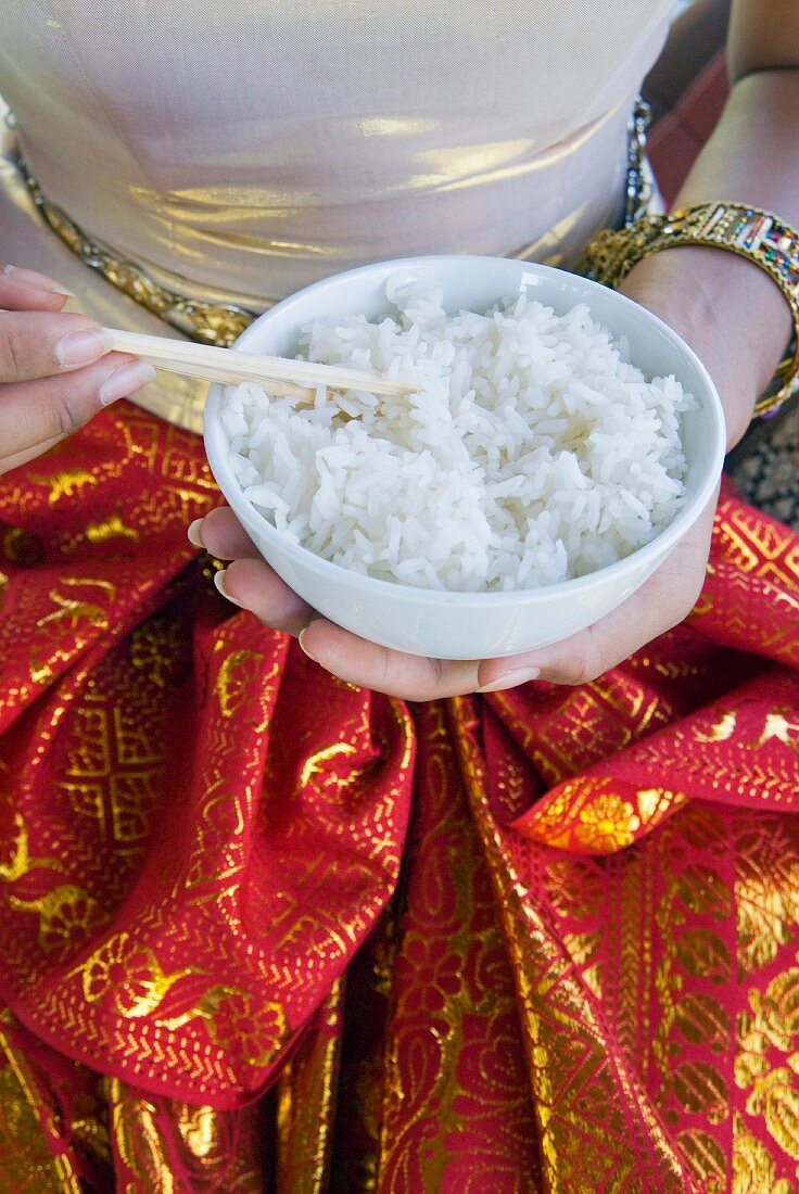 Hands holding a bowl of rice, Thailand, South-East Asia