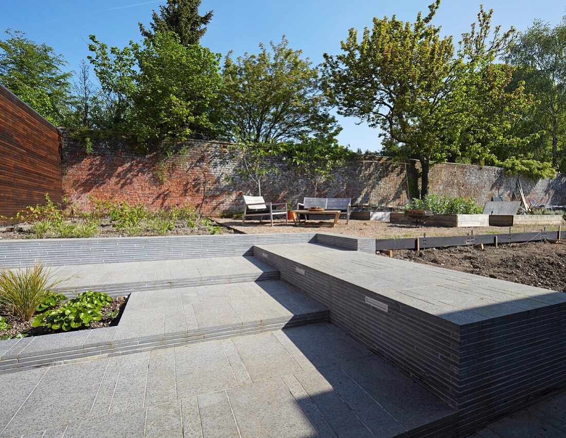 Point 7, Winchester, United Kingdom. Architect: Dan Brill Architects, 2014. Garden with seating area against high stone wall