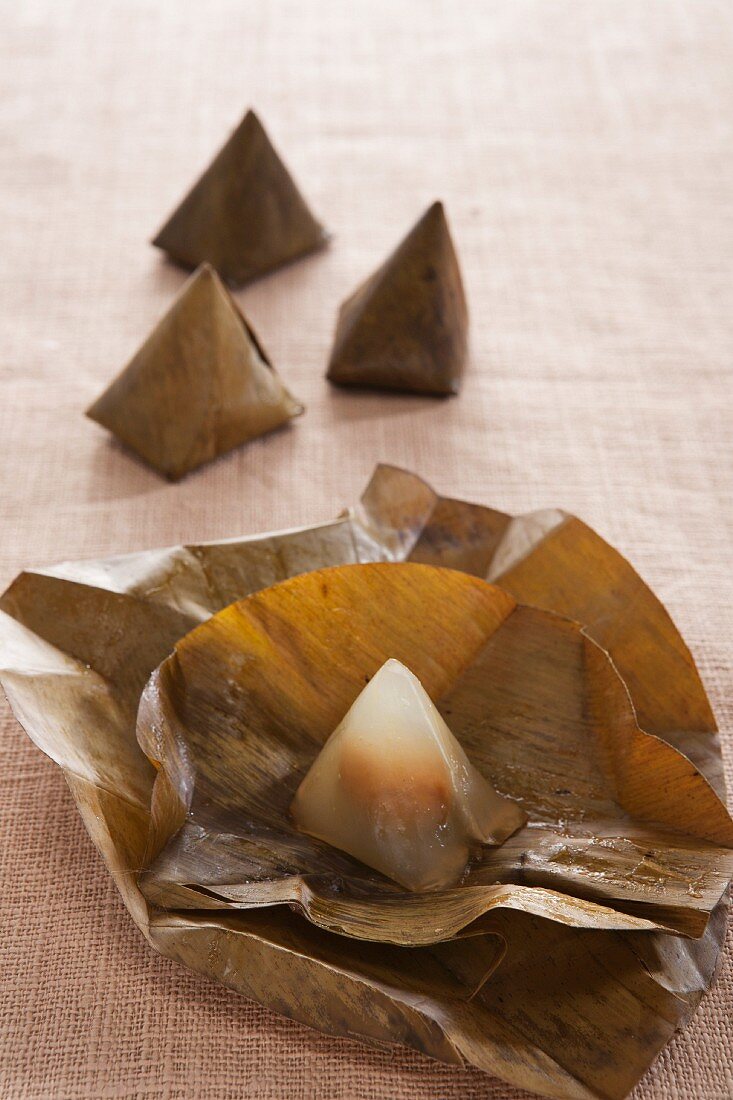 Steamed rice flour pyramids wrapped in banana leaves (dessert from Thailand)