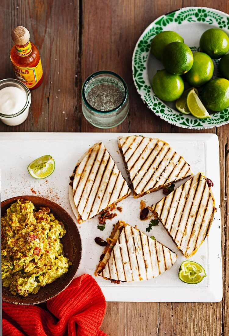 Gegrillte Rindfleisch-Bohnen-Quesadilla auf mit Guacamole, Limetten und Gewürzen