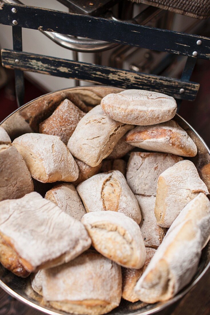 Bread rolls in a metal bowl in a baker's