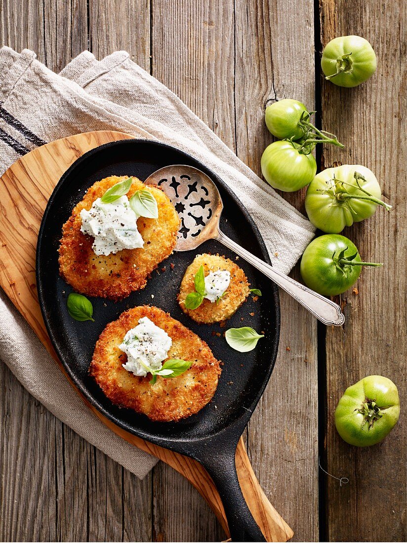 Fried, breaded green tomatoes in a pan