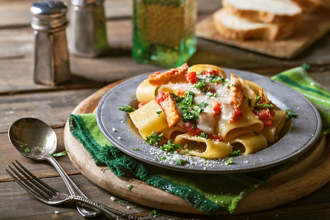 Gratinated rigatoni pasta with chicken, tomato sauce, mozzarella, parsley and grated Romano cheese