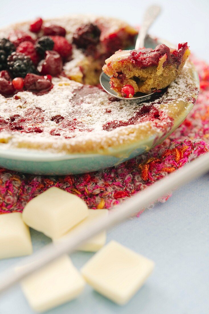 White chocolate bake with berries and icing sugar