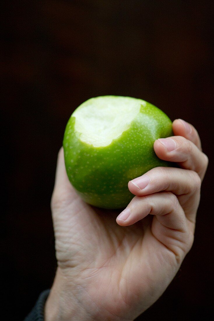 Hand Holding a Bitten Apple; White Background