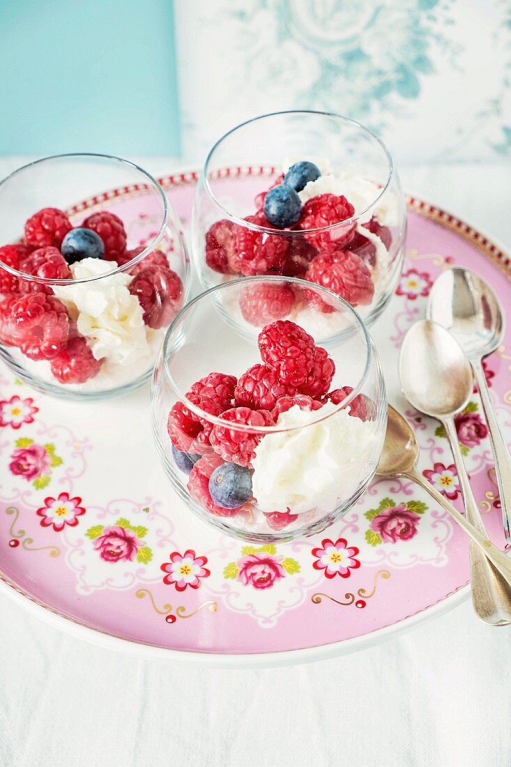 Raspberries and blueberries with cream cheese in glasses