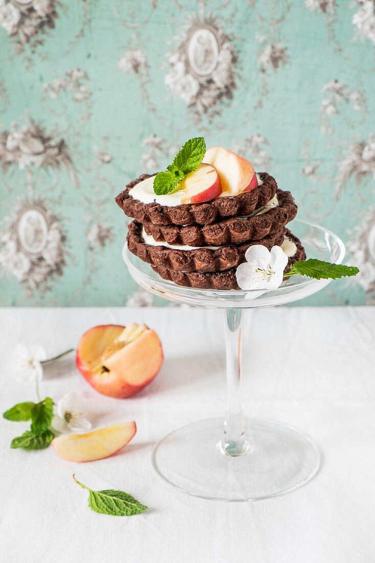 A stack of chocolate tartlets with peaches and cream cheese
