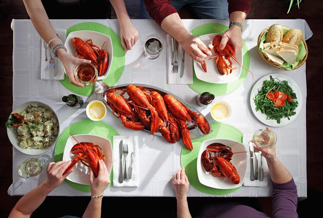 Four people eating a lobster dinner