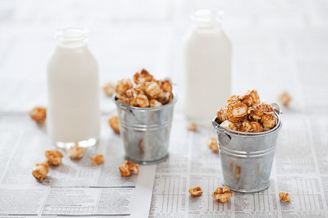 Kleine Eimer Karamell-Popcorn und Milchflaschen