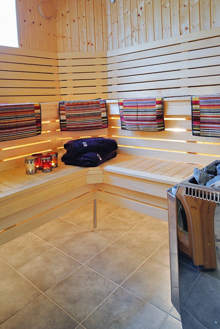 Modern sauna - colourful towels on backrest of wooden bench