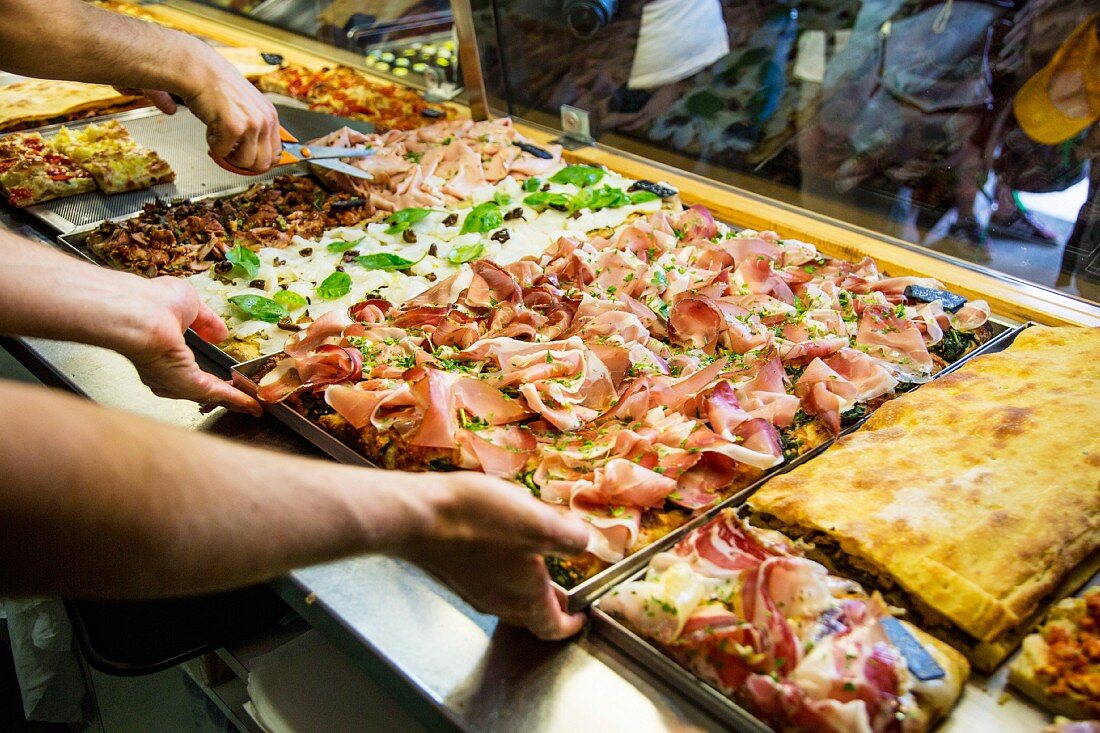 Various pizzas on display in a pizzeria (Rome, Italy)