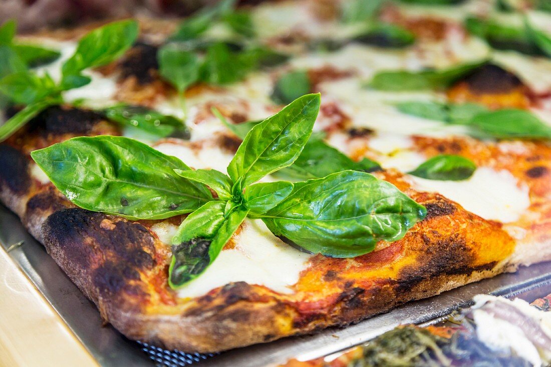 A saffron pizza with mozzarella and basil (close-up)