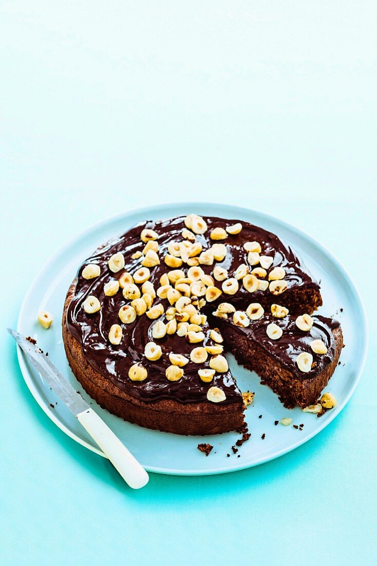 Glutenfreier Schokoladenkuchen ohne Mehl mit Haselnüssen auf einer Kuchenplatte