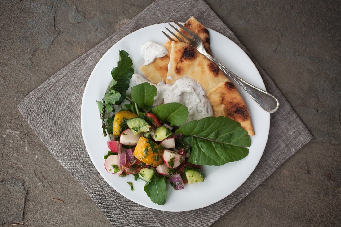Mediterranean salad with a yoghurt sauce and grilled pita bread