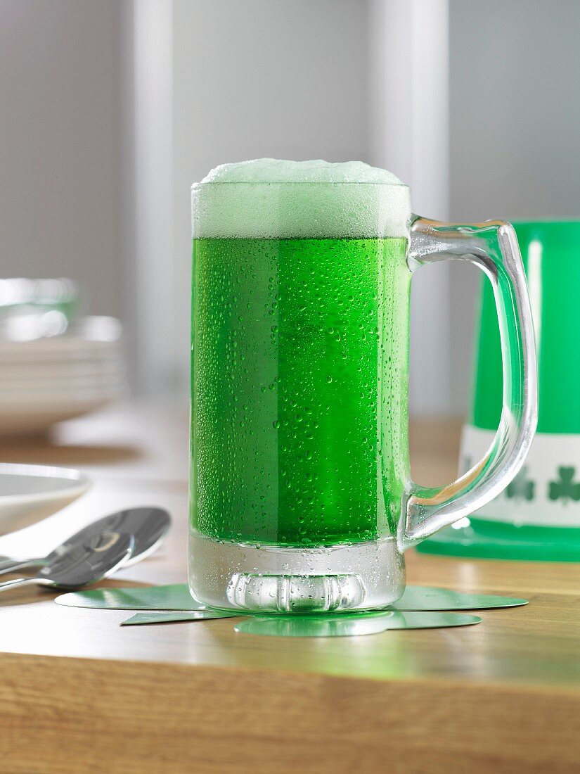 A tankard of green beer on a wooden table