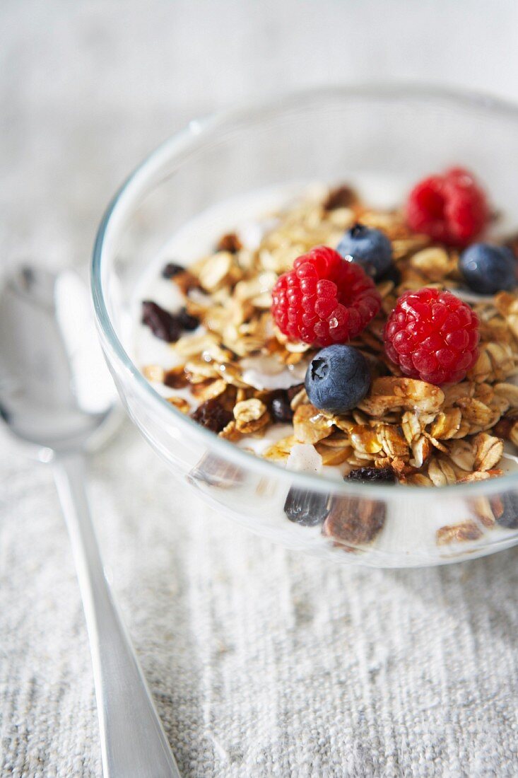 Müsli mit Trockenbeeren, frischen Himbeeren und Blaubeeren