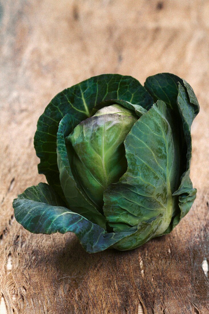 A cabbage on a wooden surface