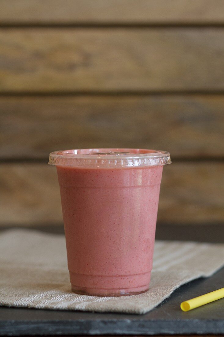 A smoothie with strawberries, almond butter, bananas and apple juice