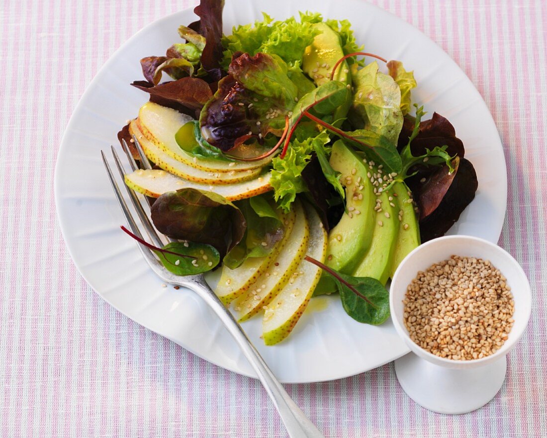 Mixed leaf salad with avocado, pears and sesame seeds