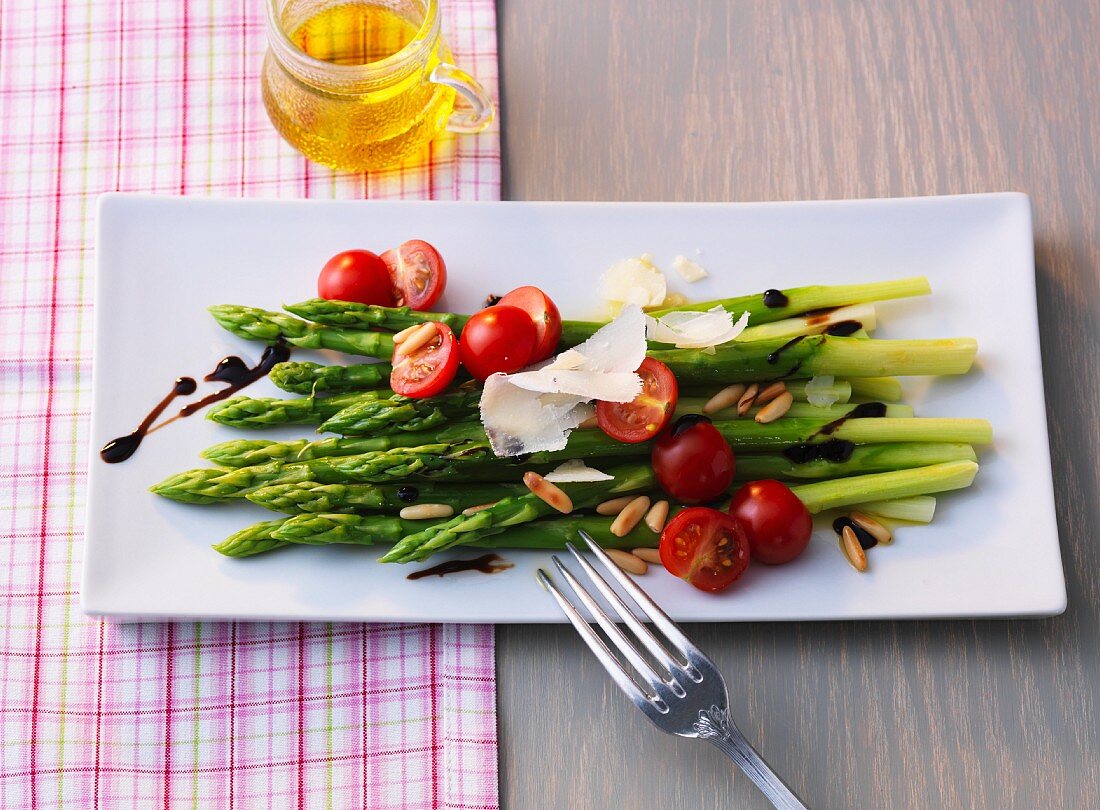 Green asparagus salad with cherry tomatoes, fresh Parmesan and pine nuts