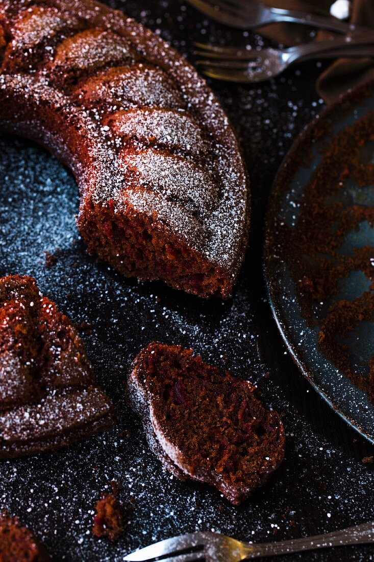 Rote-Bete-Schokoladenkuchen mit Puderzucker, angeschnitten