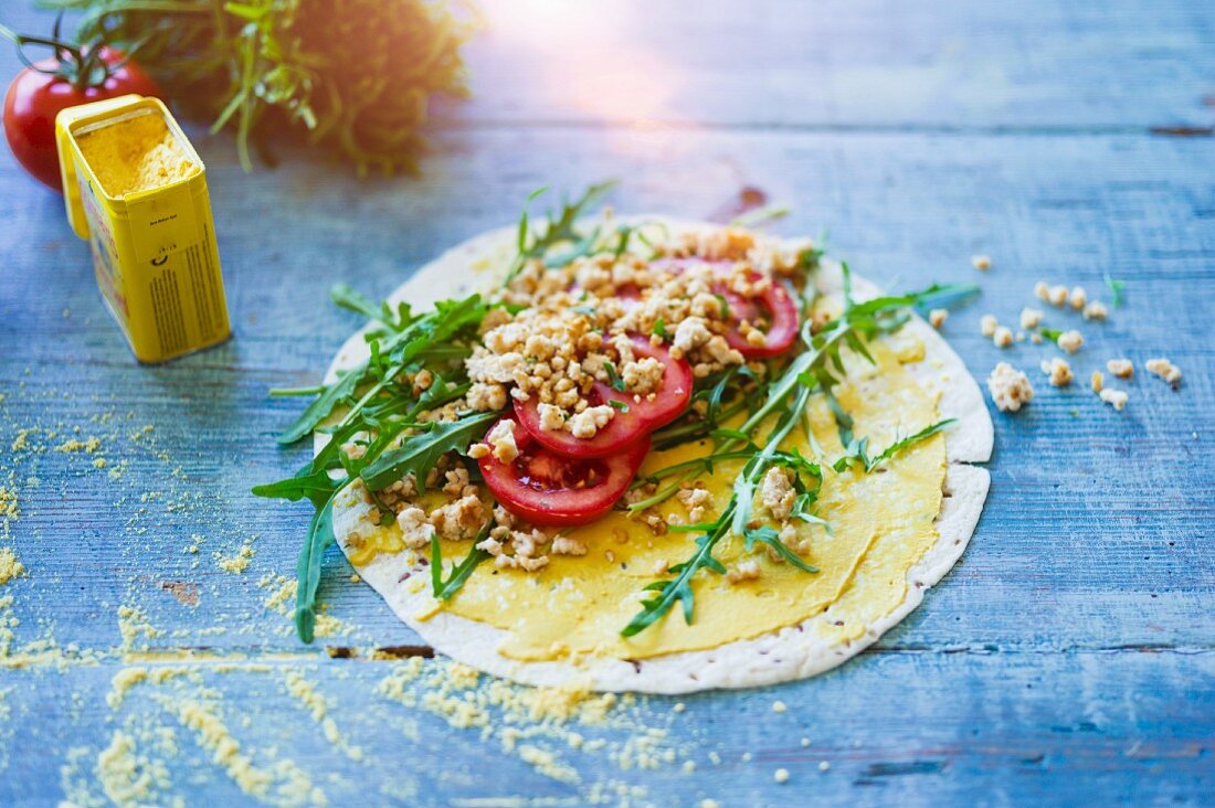 A wholemeal tortilla wrap with turkey, rocket and tomatoes