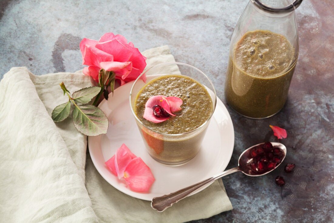 A pomegranate smoothie made with watermelon, apple, baby spinach, lime leaves and rose petals