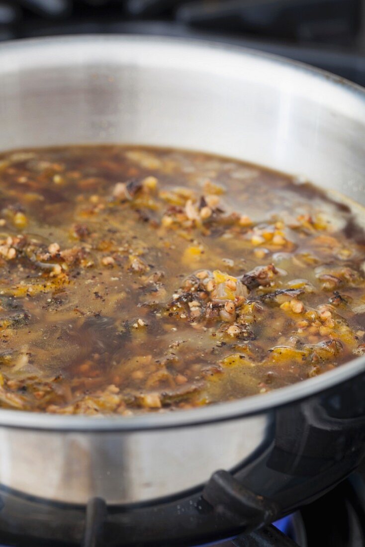 Buckwheat hash made with carrots, mushrooms and onions cooking in a pot