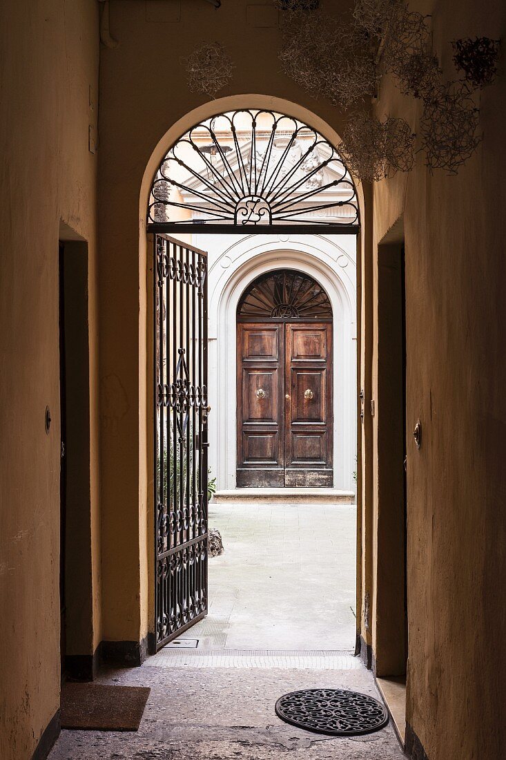 Entrance to Palazzo with wrought iron gate and view of front door of house opposite