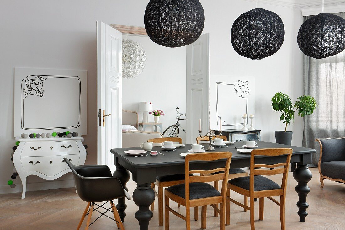 Eclectic, elegant dining room in black and white colour scheme with artworks leaning against walls and period ambiance