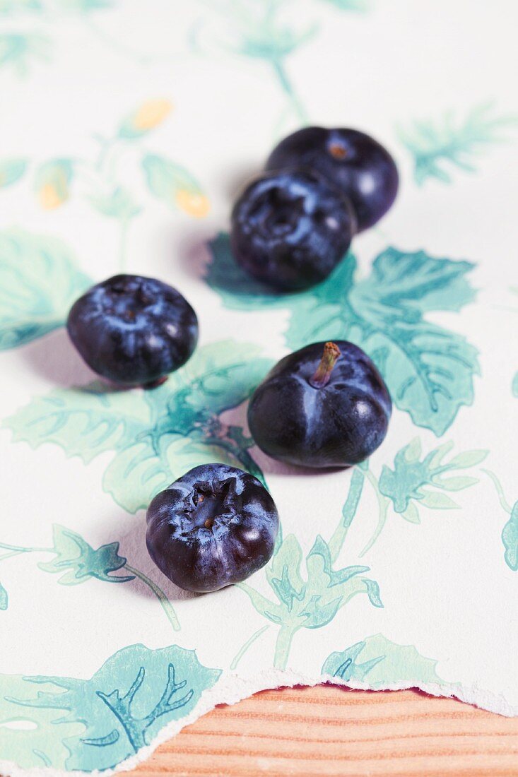 Organic blueberries on a piece of floral-patterned wallpaper