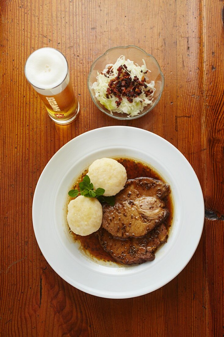 Roast pork with a bacon and cabbage salad served with beet