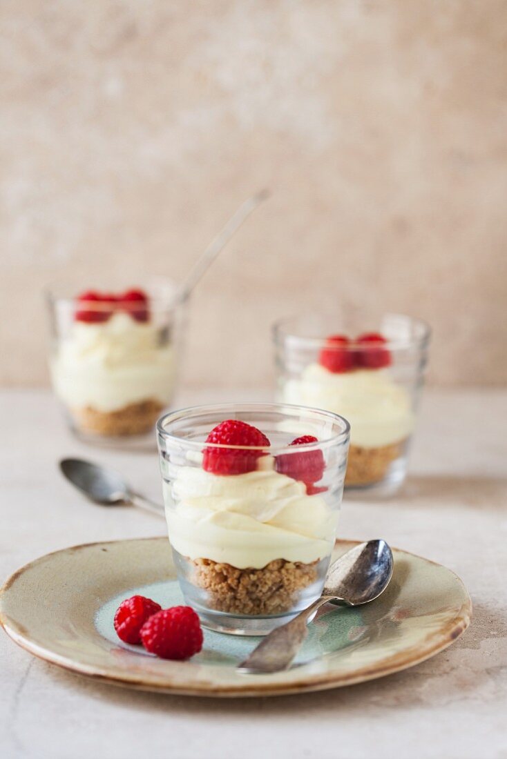 Lemon cheesecakes with raspberries in glasses