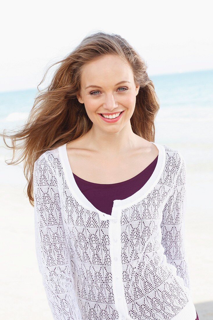 A young woman wearing a white lace jacket over a purple dress